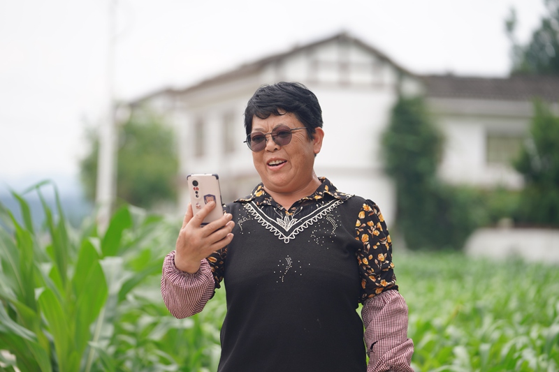 淹坝村村民钟德容正与远在浙江务工的儿子通视频。吴艳禹摄