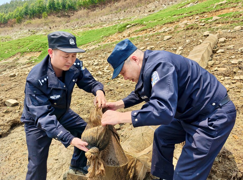 黔西南公安民警打捞清理地笼网。贵州省公安厅供图