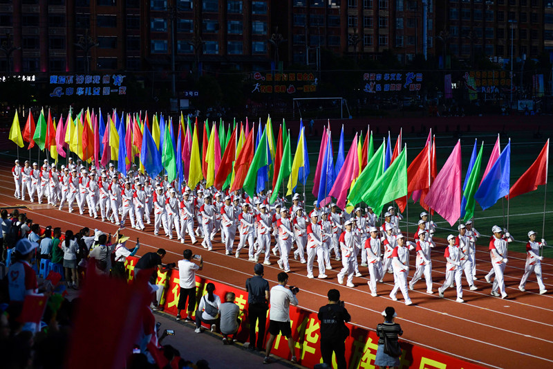 2025年8月8日，彩旗方阵在黄平县体育公园入场仪式上走过主席台。龙金艺摄