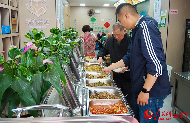 金实社区幸福食堂工作人员正帮助老人打菜。人民网 王娴摄