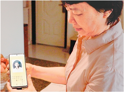 陈渝萍展示父亲陈金福回国时的护照相片。田雨轩摄