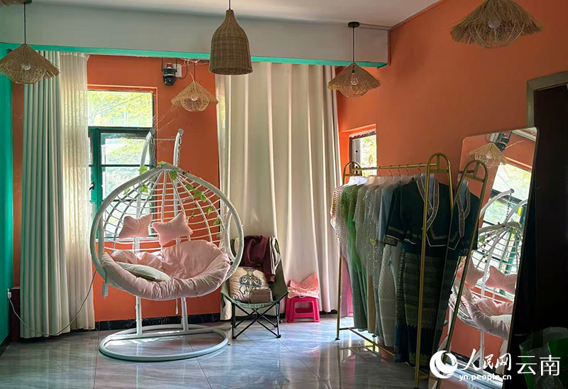 【4】临港社区居民岳顺会经营的奶茶店内，游客可以体验民族服饰拍照。人民网-雷霁摄